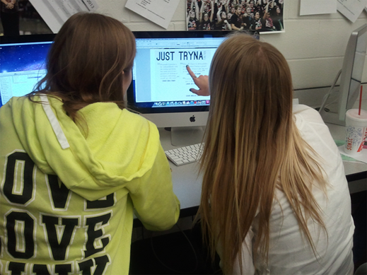 Senior Mackenzie Sipes and junior Mackenzie Lujin discuss a page design idea during a yearbook work night. All staff members are required to attend these work nights filled with music, food and interesting design ideas.