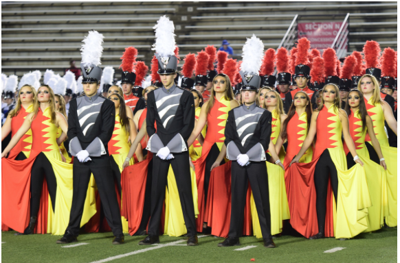 The drum majors and flag team stand in formation awaiting awards at the Bands of America marching band competition.