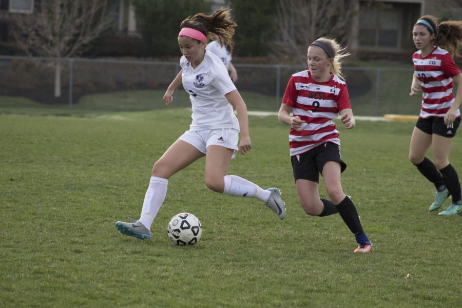 Number nine Izzy Fultz fiercely sprinting up to North rivalry to obtain the ball. 