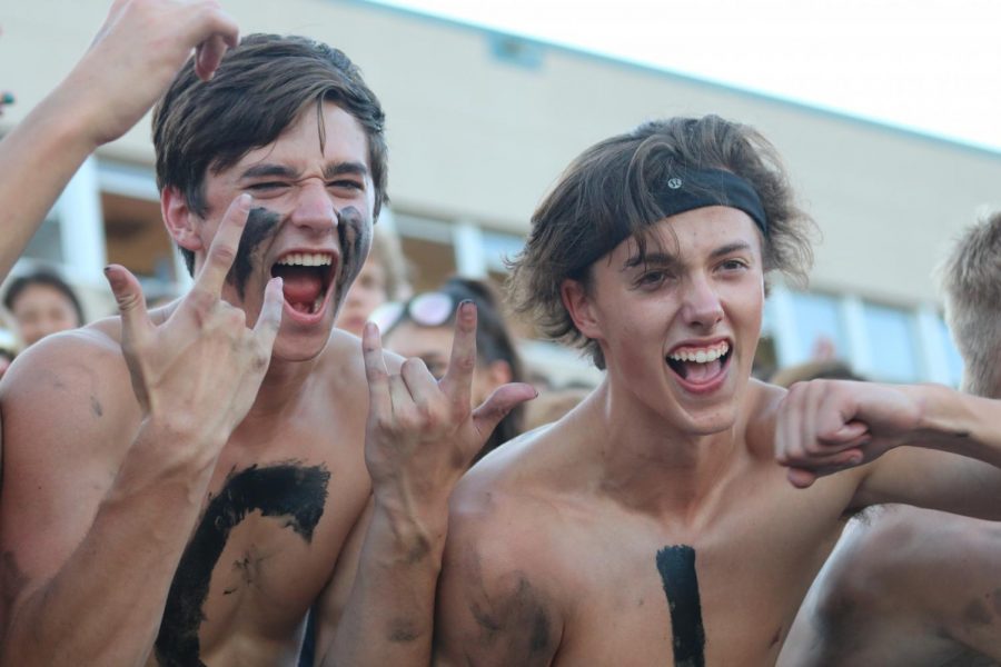 On the left, Dawson Duran and right, Coah Powell cheering on Blue Valley West football on 8/31. Both of them participated in having a letter painted on them in total spelling of Jaguars in the front row of the bleachers.