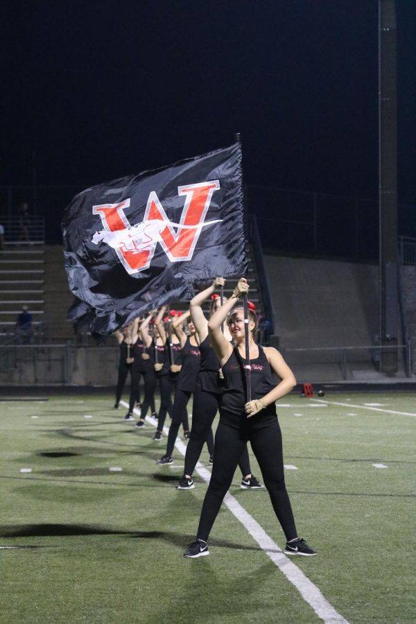 Color guard holds up Blue Valley West flags during the halftime show. They work very hard to coordinate their flag movements as well as the other dances they do during half time.