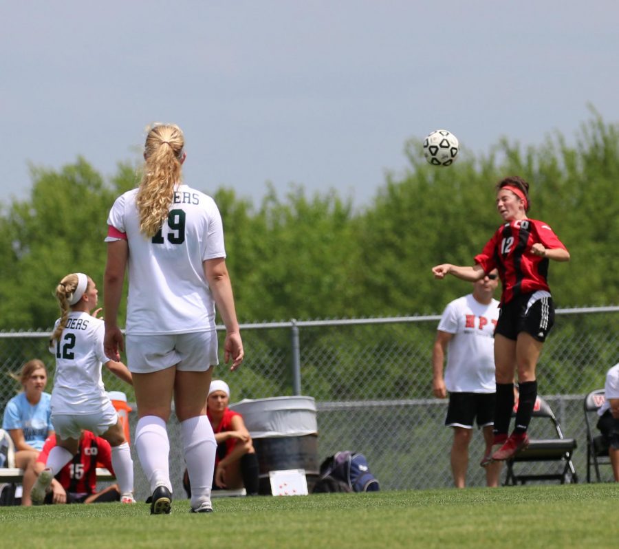 Andree Orcutt jumps up to head the ball to keep it out of scoring position for the Raiders.