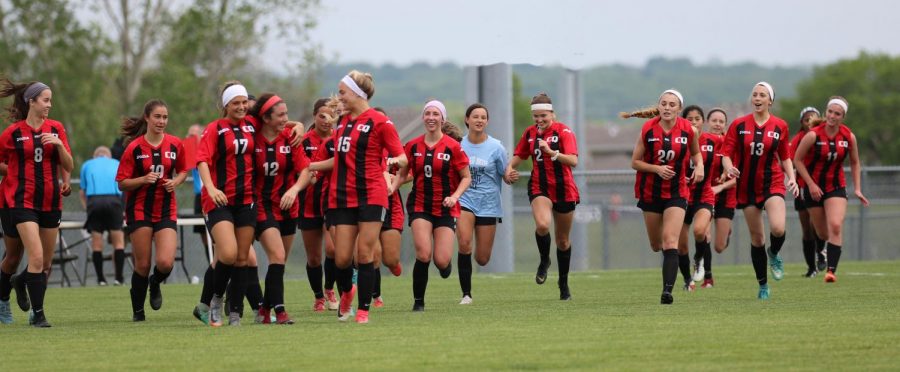 The girls soccer team runs to line up across the field a take a bow after their win over the Shawnee Mission South Raiders in the State quarterfinal game on May 22.