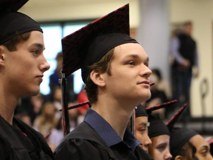Senior Tanner Powell waits to be seated as all of the class assembles in the gym for Class Day.