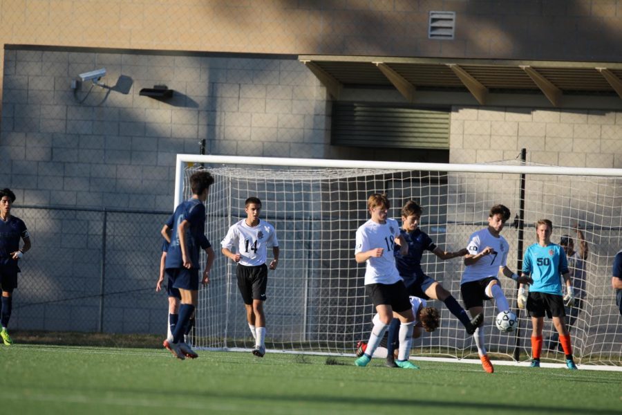 Several players help protect the goal so that junior Colin Welsh waits.
