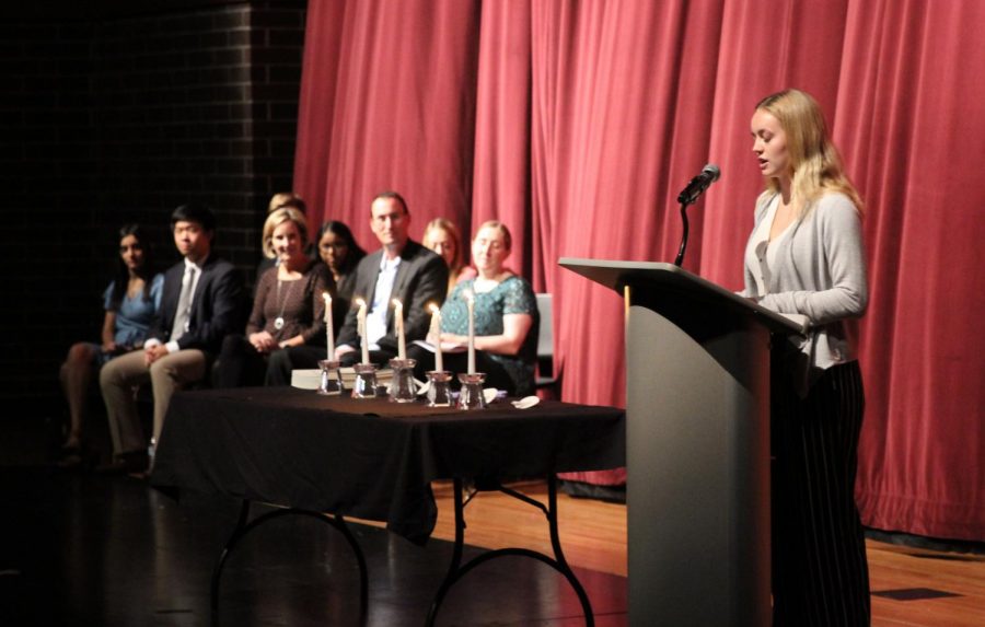 Senior Ashlyn Acheson introduces teacher Kevin Bandy at the NHS Induction Ceremony.