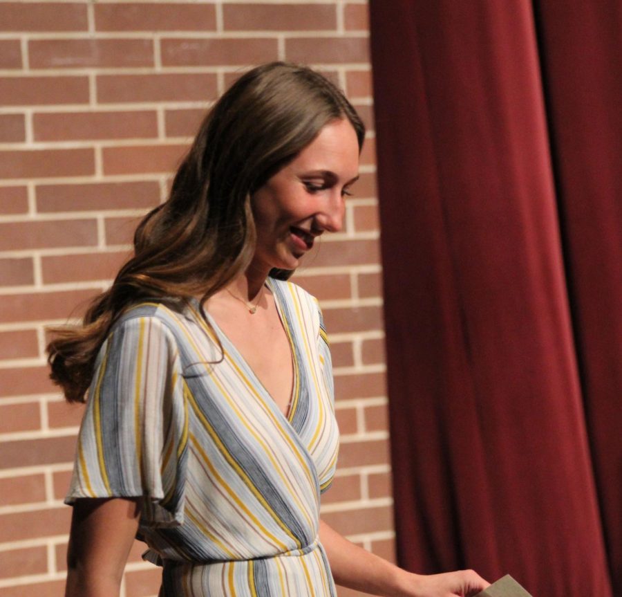 Smiling after her induction, junior Lindsey Kuhlman exits the stage.