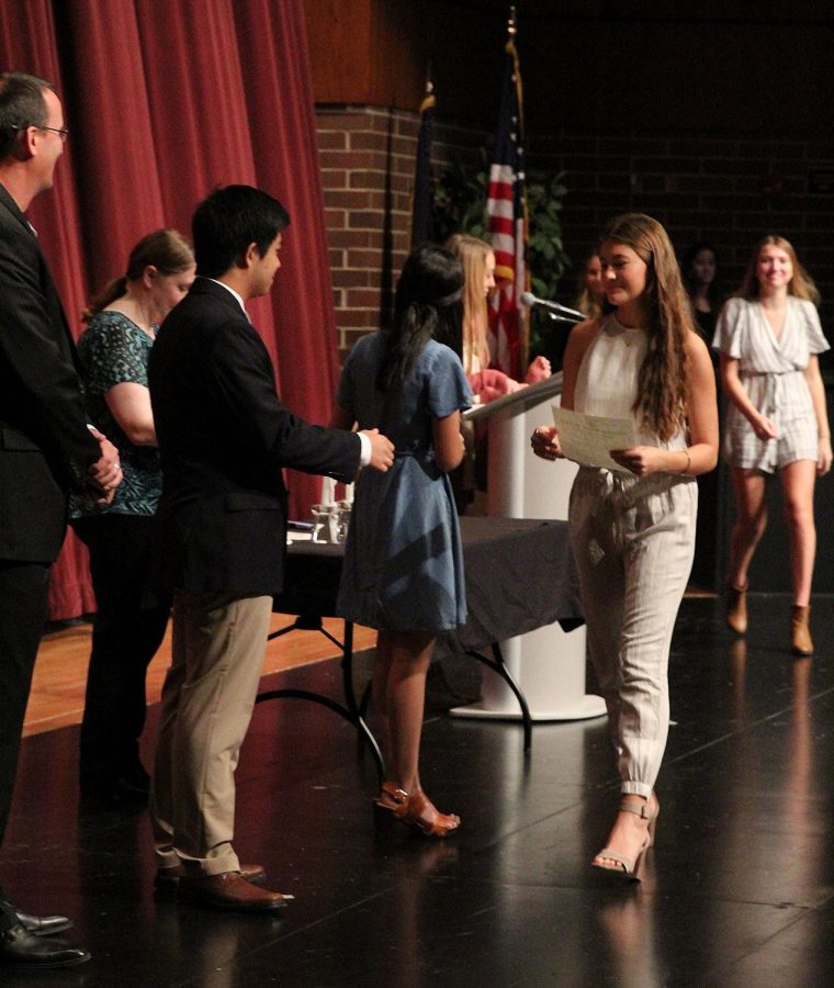Junior Ella Peters walks across the stage during the NHS Induction ceremony.