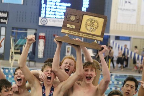 Swim team members celebrate their 6A State Championship over Olathe East on Feb. 22.