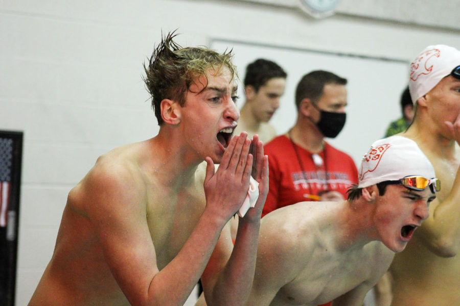Junior Aidan White cheers on his teammates during the final relay of the Boys Swim and Dive Meet on Dec. 3 vs BVN