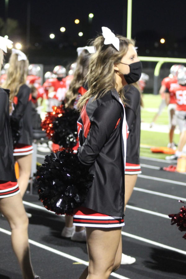 Kyra Michaelson watches the JV football team as she cheers.