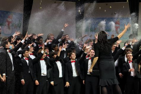 Chorale tosses fake snow in their performance of Its the Holiday Season.