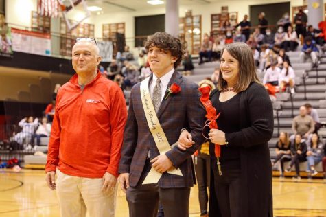 After being announced as apart of Sweetheart Royalty, Senior Matt Lancaster smiles with joy as hes supported by his parents.