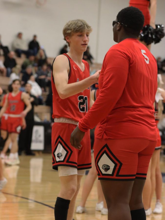 performing their routine pregame handshake, Seniors Cooper Forcellini and Dunsi Idowu fist bump before the varsity boys away game against Blue Valley North.