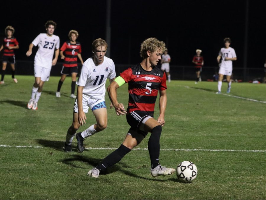 Senior Cooper Marquette  dribbling the ball down the field.