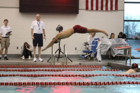 Swimmer diving in the pool during relay. 