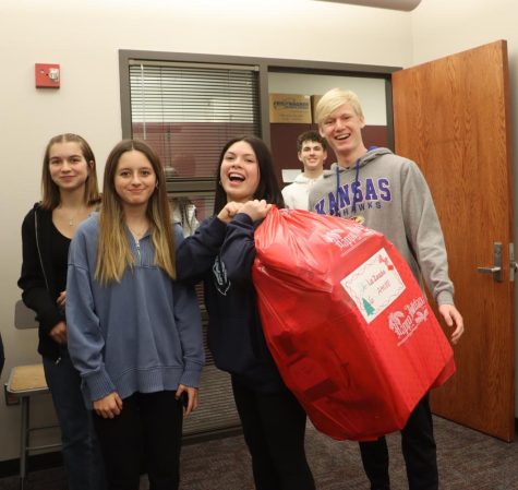 Ana Landeras, Evan Laubster andthwir advisory classmates deliver a large bag full of gifts. 