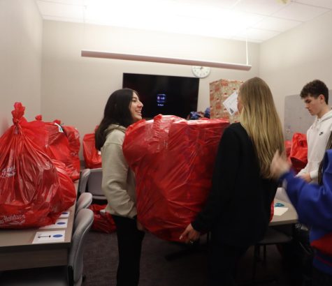 Abby McClune and Rebecca Flores work together to life their enormous red bag onto the table.