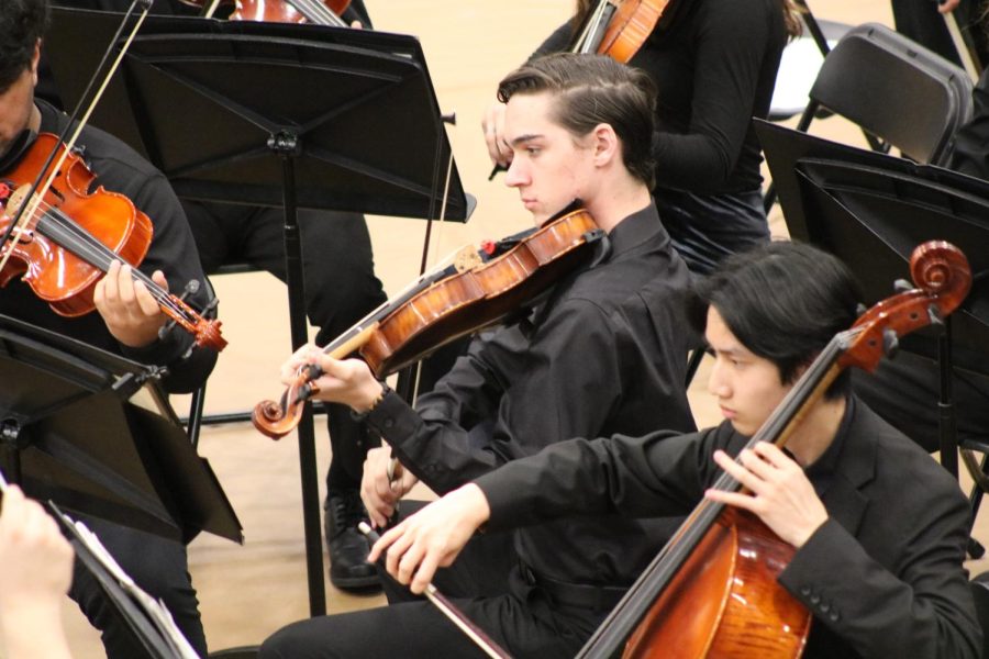 Junior Logan Engelman plays the violin during the orchestra concert. 