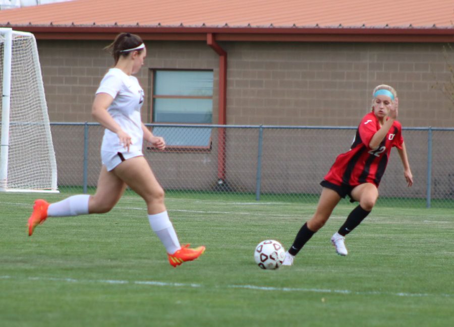 BV West soccer player runs to attempt to steal the ball from the opposing team.