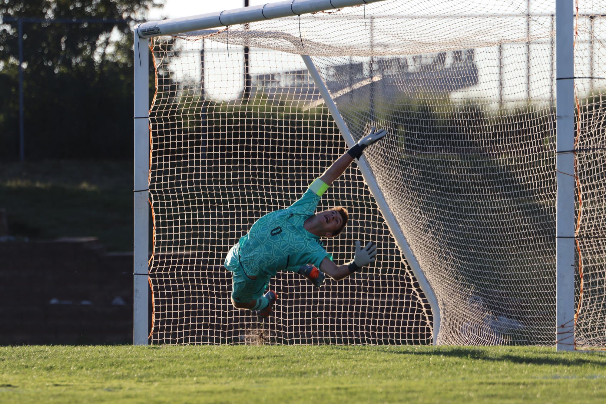 Goalkeeping Senior Carson Flake jumps in attempt to stop a PK in penalty shootout preceding BVWs win.