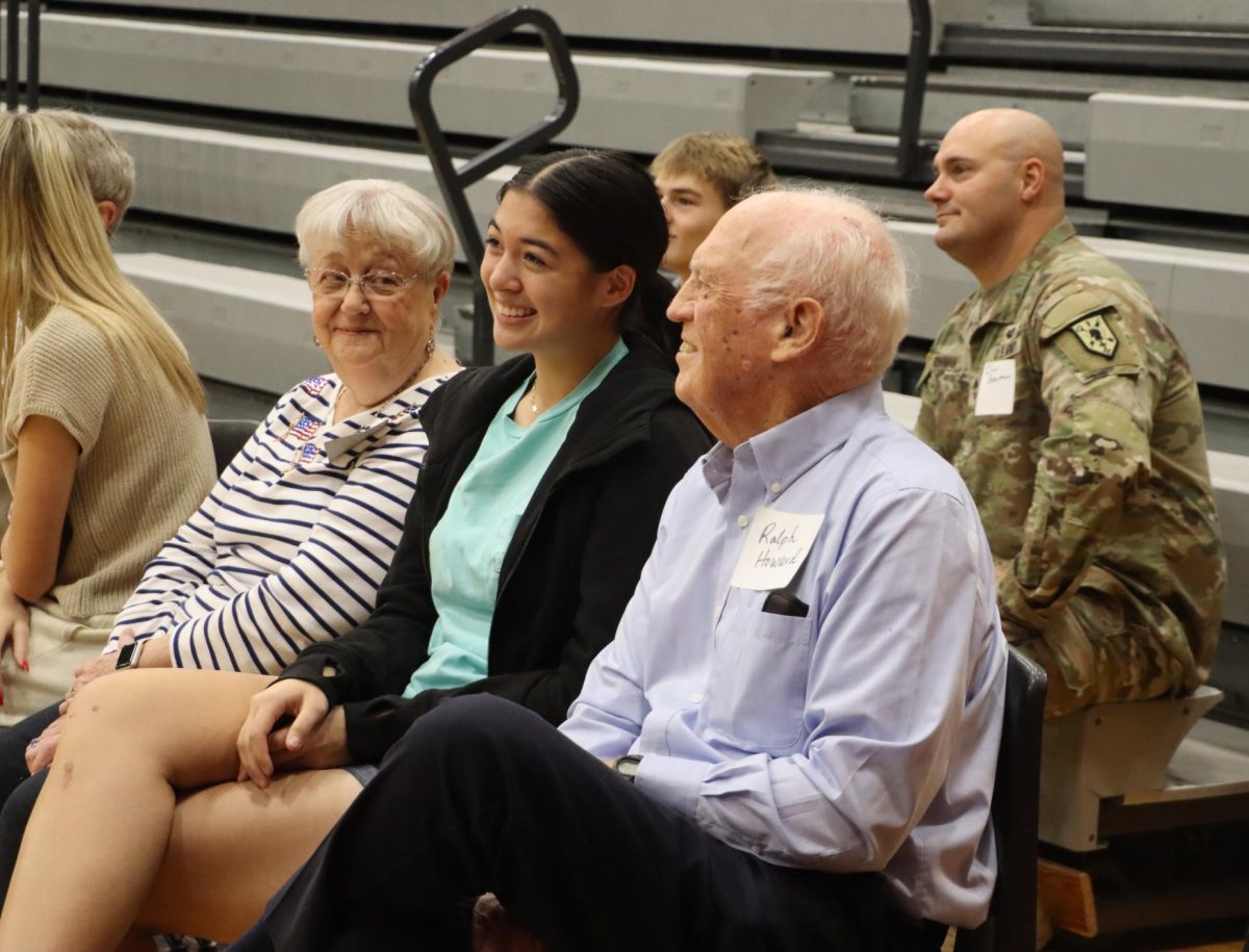 Junior Suyin Howard smiles with her grandparents as she celebrates them at the veterans day assembly 