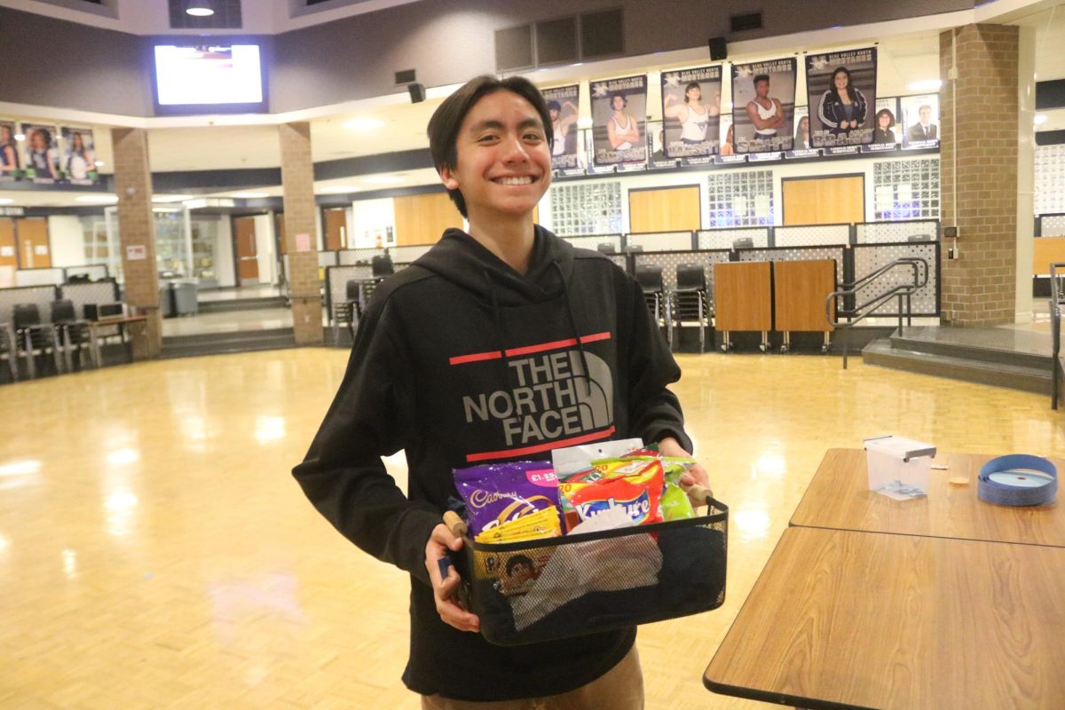 A Blue Valley West student poses victoriously as he claims his prize for winning the Diversity Festival Raffle.