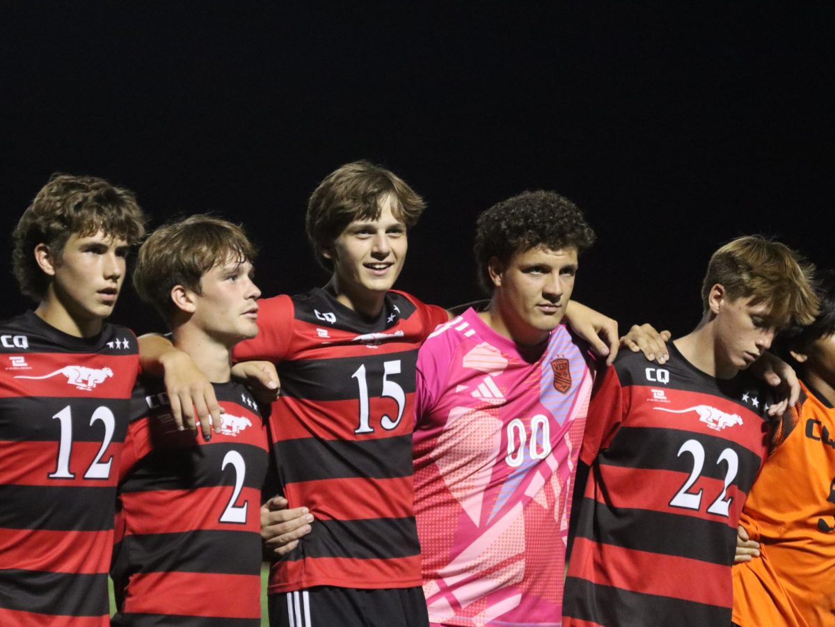 Boys soccer players singing the Alma Mater together at the end of their game against Lincoln Prep.