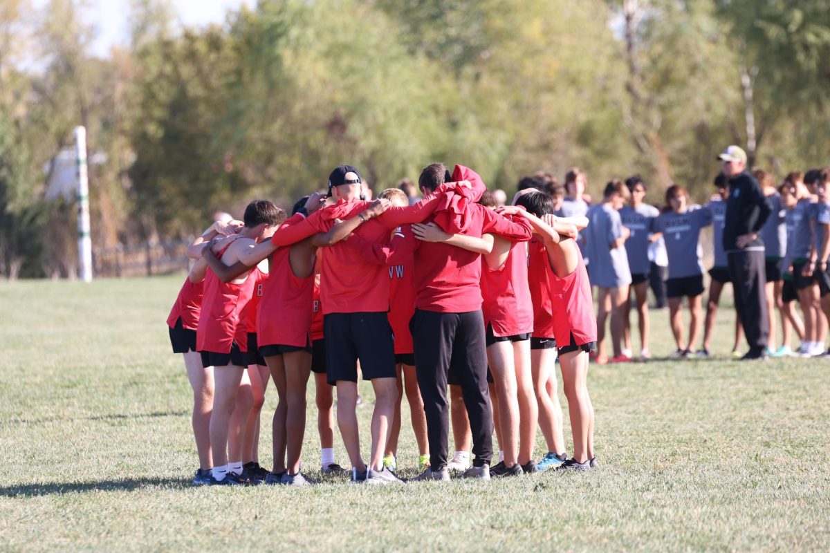 The boys JV cross country team huddles before the race starts.