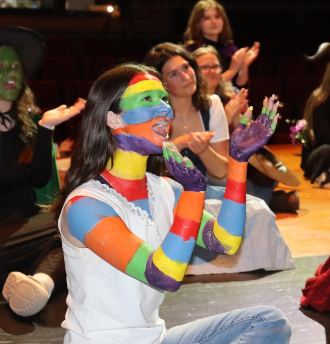 Sophomore Charlotte Hargrove applauds in her Camilla Cream costume.