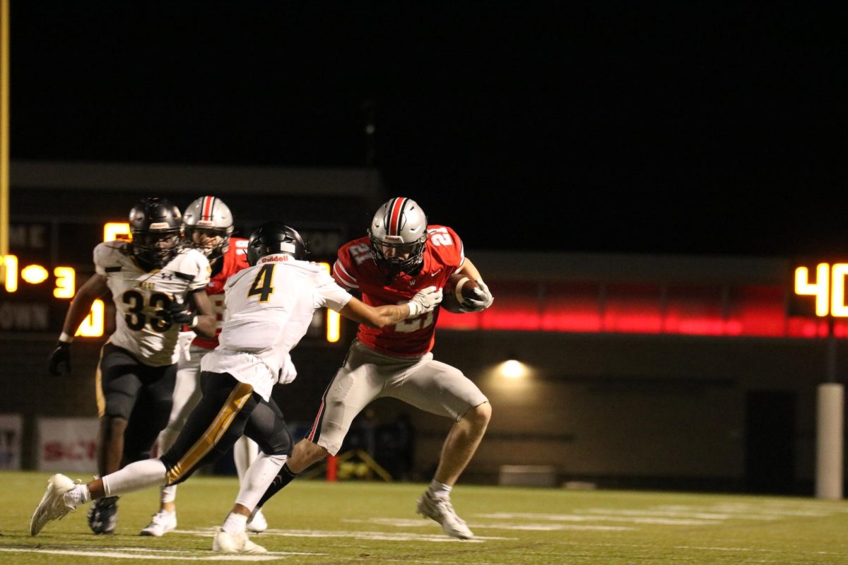 Senior Tate Miller runs with the ball away from his opponent.