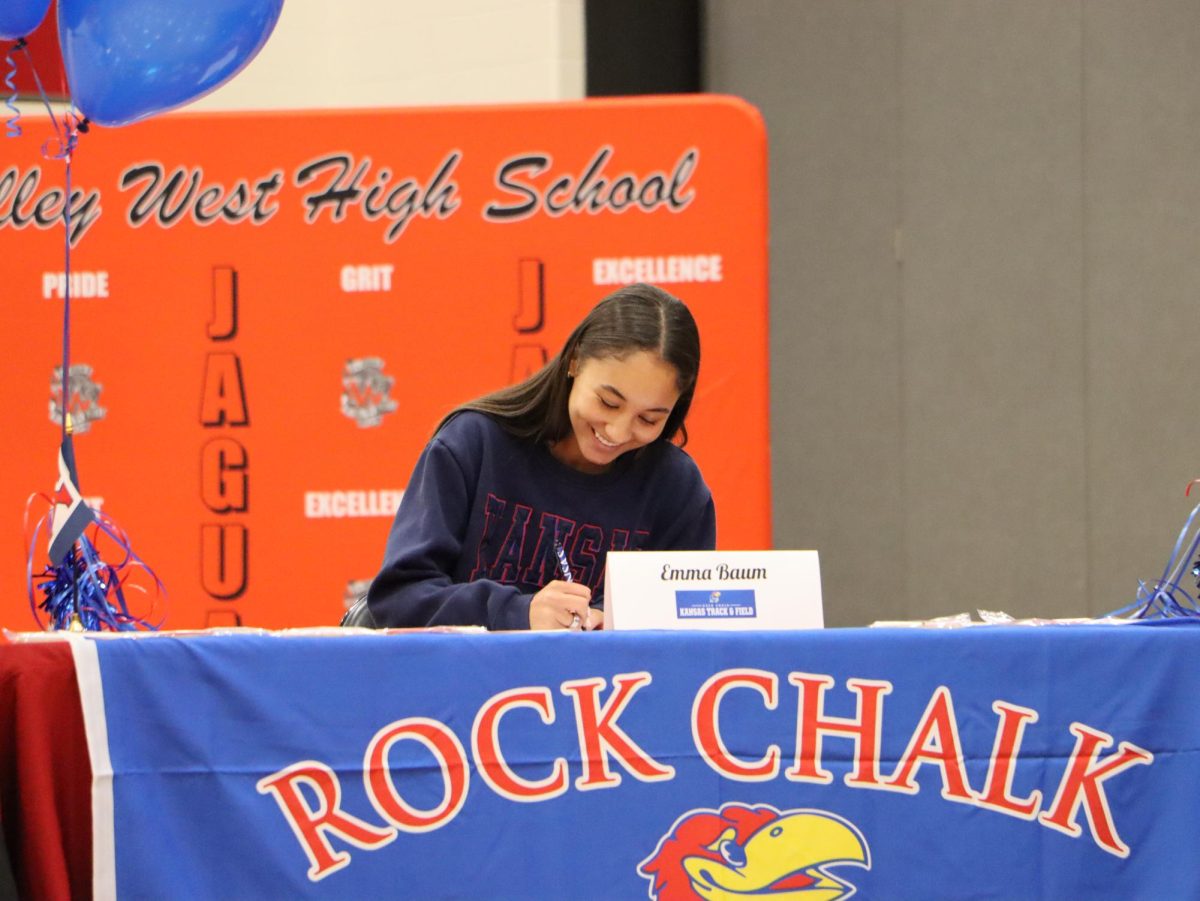 Senior Emma Baum signs her paper to run track at the University of Kansas