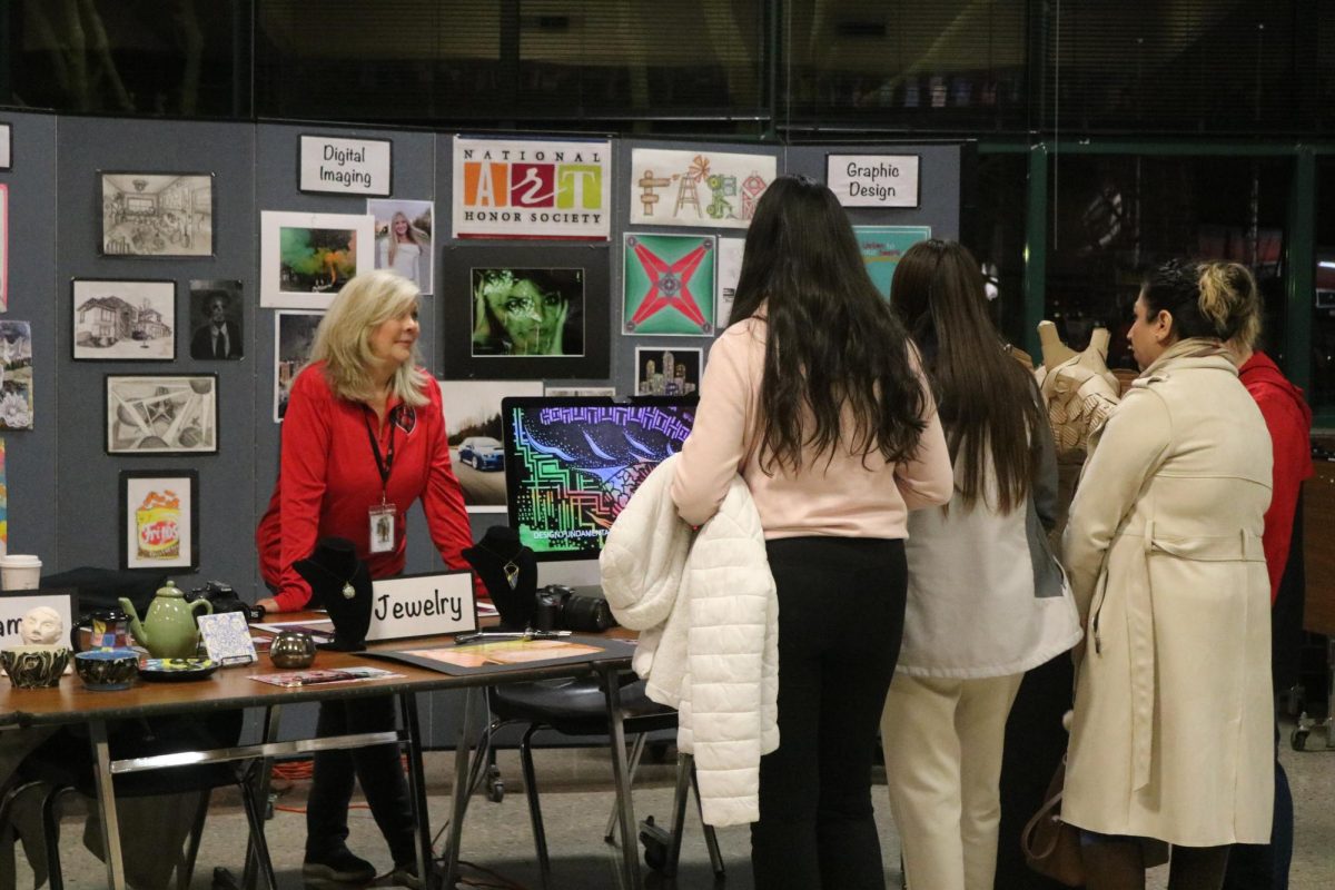 One of the art teachers explaining to incoming freshman and their family about what her class is about. 