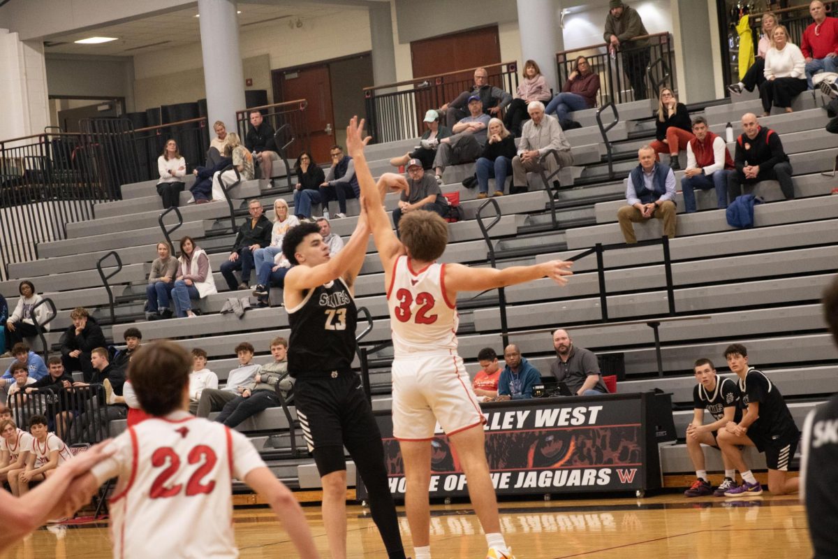 Junior Colton Weisguth jumps up to stop a Northwest player from getting the point.