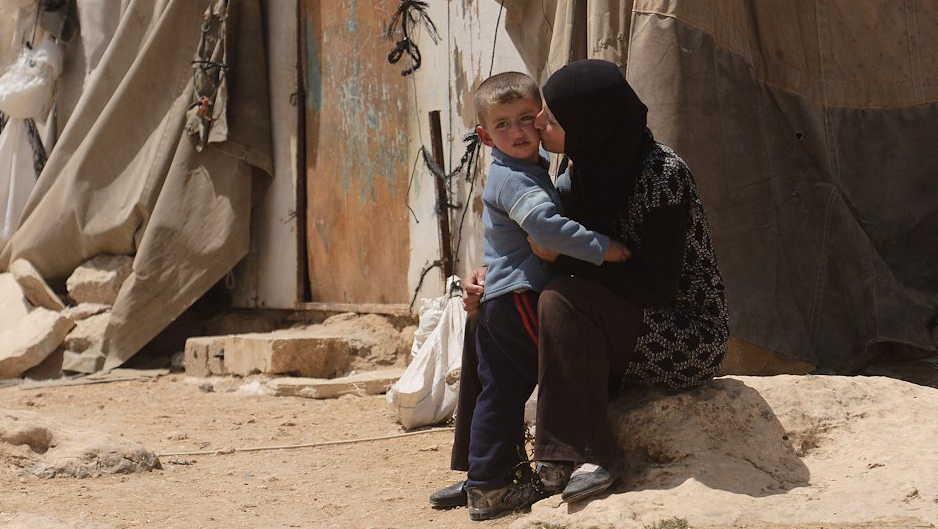 A woman hugs her child are in a war-torn region of the Middle East.